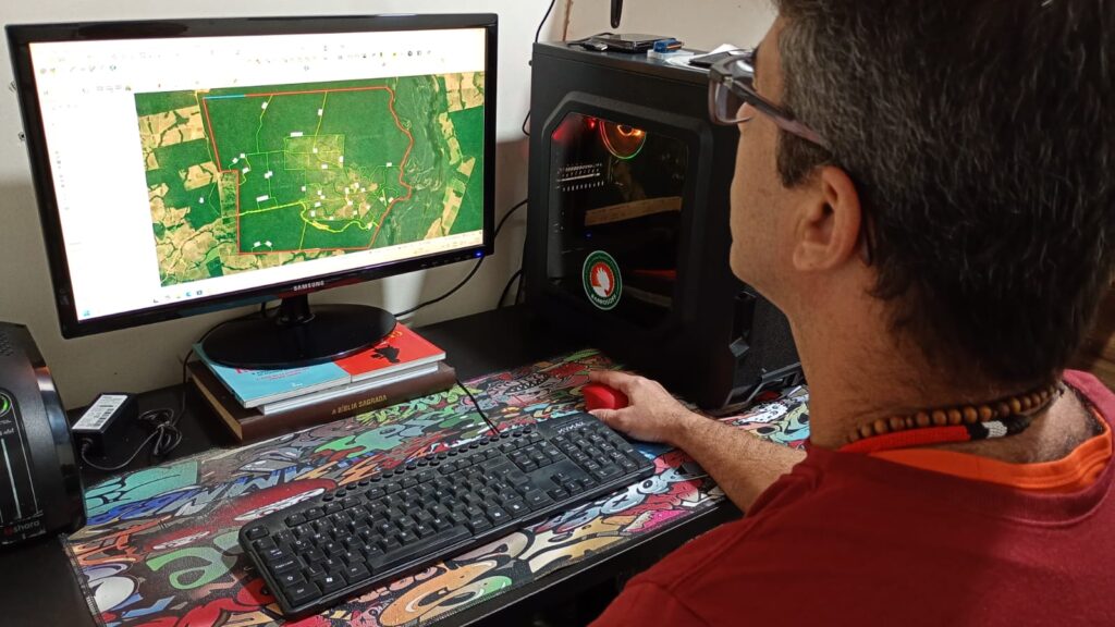 Especialista da Barrosoff Engenharia analisando mapa territorial com polígonos no monitor para simulação de áreas de risco.